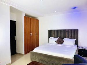 a bedroom with a large bed with a wooden headboard at Vintage Classic Lodge in Lagos