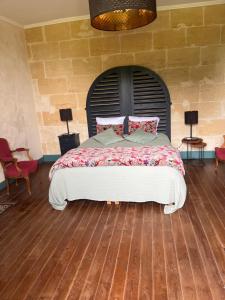 1 dormitorio con 1 cama grande y pared de ladrillo en Gîte du Château La Rose des Vents en Puisseguin