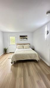Habitación blanca con cama grande y suelo de madera. en Stylish and Cozy 2BR in Mar Vista, en Los Ángeles