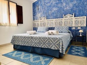 Un dormitorio azul con una cama con toallas. en Casagliana Suite Resort en Olbia