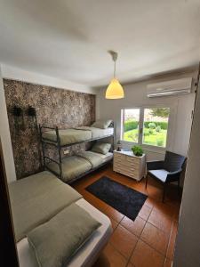 a room with two beds and a chair and a window at Casa El Grande in Torrevieja