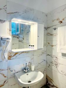 ein Bad mit einem Waschbecken und einem Spiegel in der Unterkunft Nefeli Studios in Vathy