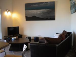 een woonkamer met een bank en een tafel bij Promesse de vacances réussies in Calcatoggio