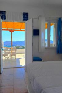 a bedroom with a bed and a view of a patio at Georgia Rooms Milos in Plaka Milou
