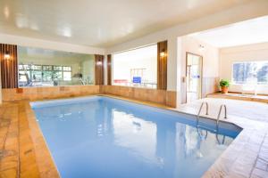 a large swimming pool in a room with a large mirror at VELINN Hotel Fazenda Fonte das Hortênsias in Santo Antônio do Pinhal