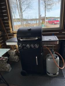 a stove and a tea kettle next to a window at Verlan Satumaa in Verla