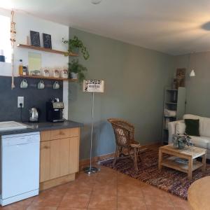 eine Küche und ein Wohnzimmer mit einem Sofa und einem Tisch in der Unterkunft Gîte des Hirondelles in La Noë