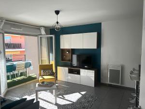 een woonkamer met een tv en een bank en een tafel bij Douceur en Ville Saint Raphel in Saint-Raphaël