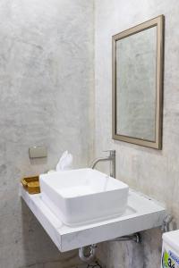 un lavandino bianco in un bagno con specchio di Rapina House a Mai Khao Beach