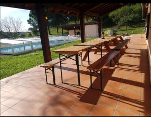 - une rangée de tables de pique-nique en bois sur une terrasse dans l'établissement Love Room- Spa- Escale Amoureuse, à Puygaillard-de-Quercy