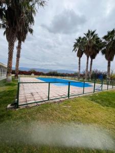 un campo da tennis con palme sullo sfondo di Depto. a estrenar en Mendoza. a Las Heras
