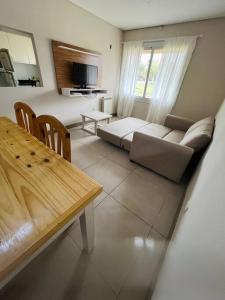 ein Wohnzimmer mit einem Sofa und einem Tisch in der Unterkunft Depto. a estrenar en Mendoza. in Las Heras