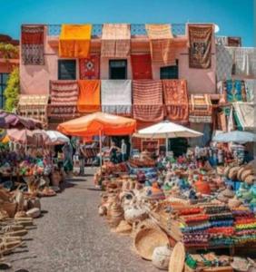 um mercado com guarda-chuvas e outros itens em frente a um edifício em riad cherif em Marrakech