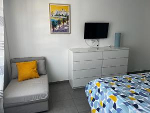 een slaapkamer met een bed en een dressoir met een televisie bij Douceur en Ville Saint Raphel in Saint-Raphaël