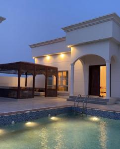 a house with a swimming pool in front of a house at شاليه alrabe3 