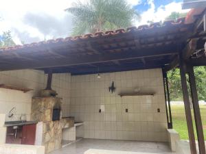 an outdoor kitchen with a wooden pergola at Chácara Vitória in Surubi