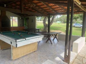 a pool table sitting under a pavilion with a table and a pool table at Chácara Vitória in Surubi +4 photos