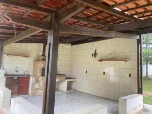 an outdoor kitchen in a house with a wooden ceiling at Chácara Vitória in Surubi