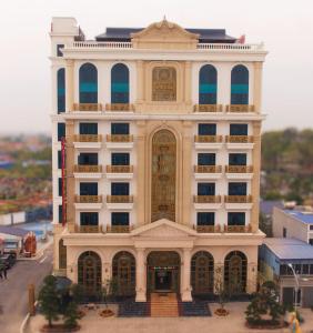 un grande edificio bianco con una grande porta dorata di Nguyễn Đức DC Hotel & Spa a Hai Phong
