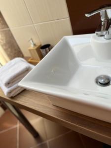 - un lavabo blanc dans la salle de bains sur un comptoir en bois dans l'établissement Panorama Hlohovec, à Hlohovec