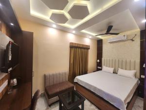 a bedroom with a bed and a chair in it at Granotel in kolkata