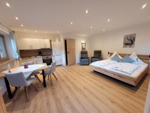 1 dormitorio con cama, mesa y cocina en Gästehaus Eckau Ferienwohnungen en Ramsau