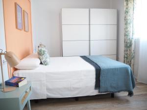 ein Schlafzimmer mit einem weißen Bett mit einer blauen Decke in der Unterkunft Agua Salá A 200m de la playa zona tranquila in Morche