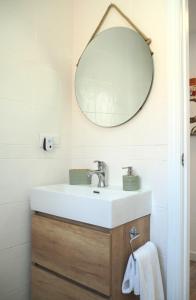 ein Bad mit einem Waschbecken und einem Spiegel in der Unterkunft Agua Salá A 200m de la playa zona tranquila in Morche