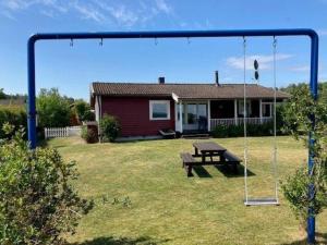 a swing in a yard in front of a house at Ferienhaus in Tibro mit Kleinem Garten in Tibro