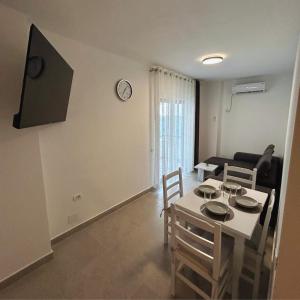 a living room with a table and chairs in a room at Rana Hedhun Apartment in Margjonaj
