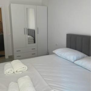 a bedroom with a bed with two towels on it at Rana Hedhun Apartment in Margjonaj