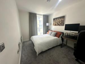- une chambre avec un lit et un bureau avec un ordinateur dans l'établissement RJO Apartments Chatham, à Brompton