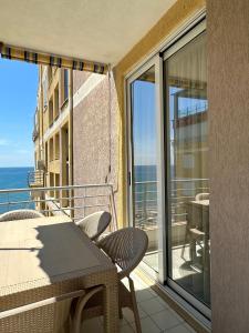 balcón con mesa, sillas y vistas al océano en Eri Apartments, en Shëngjin