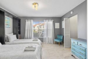 a bedroom with two beds and a blue chair at 2BD/2BA Condo w/ Beach Access & Pool Isla del Sol in St Petersburg +21 photos