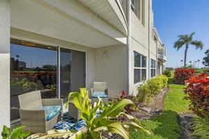 a patio with chairs and plants next to a house at 2BD/2BA Condo w/ Beach Access & Pool Isla del Sol in St Petersburg