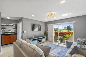 a living room with a couch and a tv at 2BD/2BA Condo w/ Beach Access & Pool Isla del Sol in St Petersburg