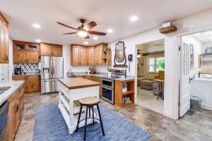 a kitchen with wooden cabinets and a ceiling fan at Beaver Lake Getaway with 2 Decks, Grill, and Views! in Garfield