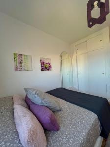a bedroom with a bed with pillows on it at Apartamento en primera línea de la playa a 15 minutos de la Ciudad de Valencia in Valencia +12 photos