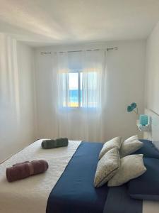 a bedroom with a large bed with a window at Apartamento en primera línea de la playa a 15 minutos de la Ciudad de Valencia in Valencia