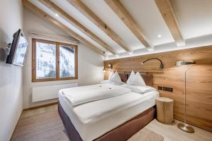 Un dormitorio con una cama grande y una ventana en Chalet Silvretta Hotel & Spa, en Samnaun