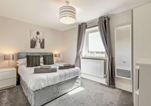 ein Schlafzimmer mit einem großen Bett und einem Fenster in der Unterkunft Scarlettrose in Great Torrington
