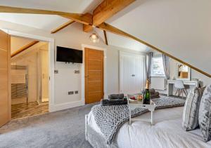 ein Wohnzimmer mit einem Bett und einem Tisch in der Unterkunft Scarlettrose in Great Torrington