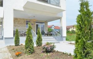 una casa bianca con portico con tavolo e sedie di Abi Mykonos a Mamaia Nord - Năvodari