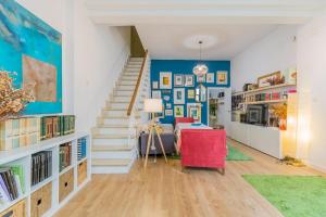 ein Wohnzimmer mit einer Treppe und einem roten Stuhl in der Unterkunft Tu estancia perfecta en Sevilla in Sevilla