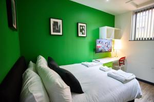 MCCARTNEY SUITE 5 BEDS في ليفربول: غرفة نوم خضراء بسرير ابيض بجدار اخضر
