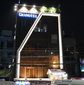 a building with a sign on top of it at night at Granotel in kolkata