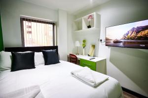 STARR SUITE 6 BEDS في ليفربول: غرفة نوم مع سرير وتلفزيون بشاشة مسطحة على الحائط