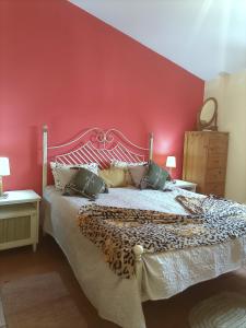 sypialnia z dużym łóżkiem z czerwoną ścianą w obiekcie Casa à Porta do Torreão w mieście Silves