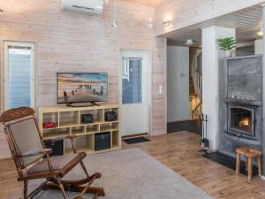 ein Wohnzimmer mit einem Kamin und einer Holzwand in der Unterkunft Holiday Home Pikku-pölly by Interhome in Vuokatti