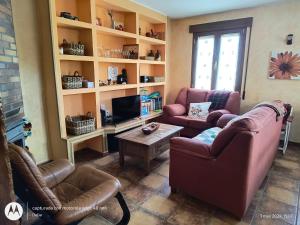 sala de estar con 2 sofás y TV en Casa Rural Casa Jacinta, en San Cristóbal de Segovia